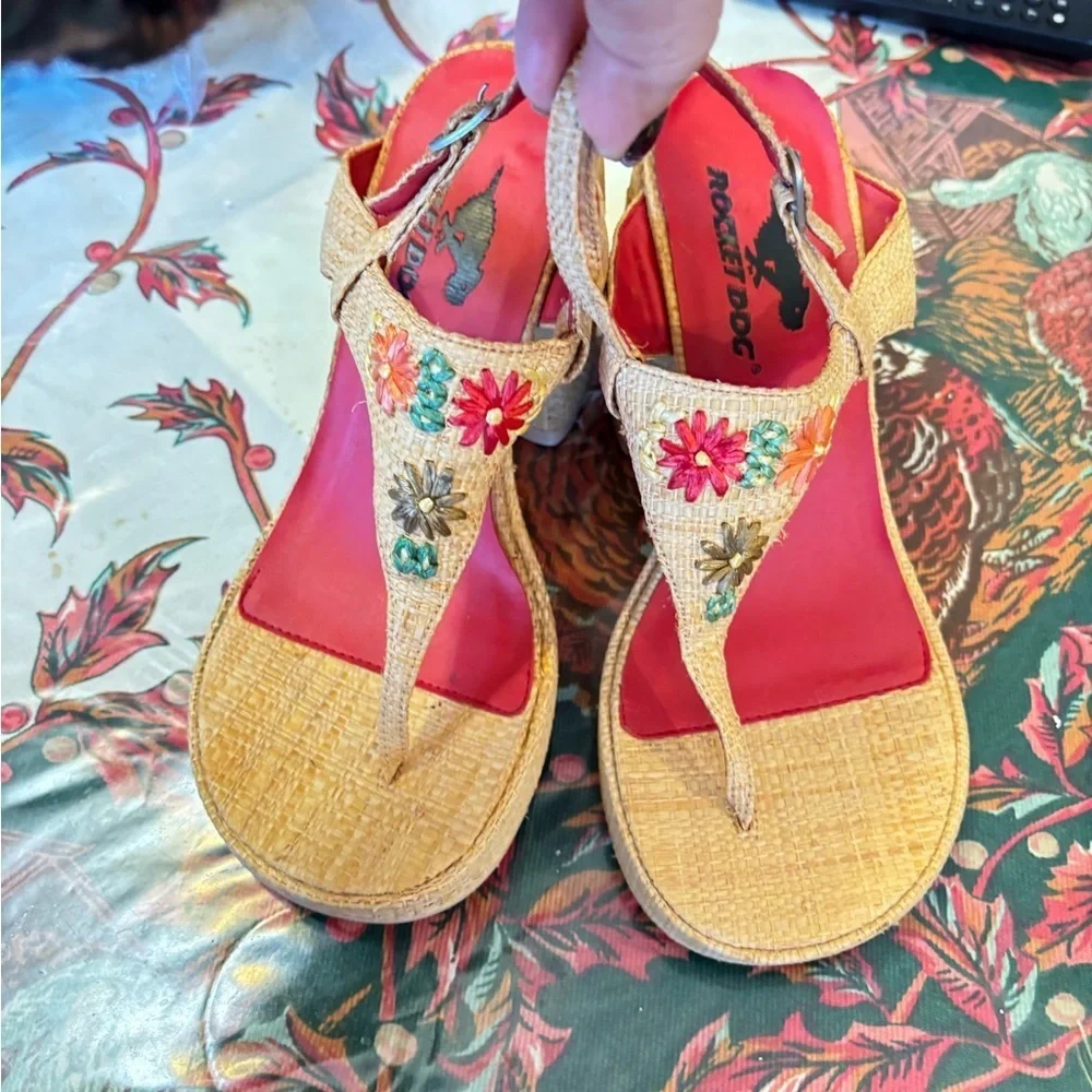 Rocket Dog brand wedges sandals with raffia uppers and floral embellishments.